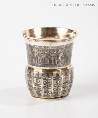 a silver cup sitting on top of a white table