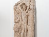 une sculpture en pierre représentant un homme et une femme sur un socle