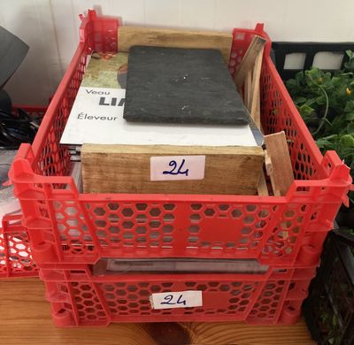 un panier rouge rempli de livres posé sur une table en bois