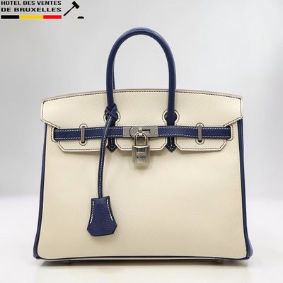 un gros plan d'un sac à main blanc et bleu posé sur une table