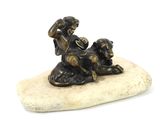 figurine en bronze représentant un garçon et un chien assis sur un rocher
