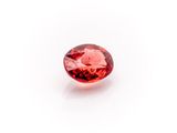 a close up view of a red diamond on a white surface