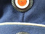 two buttons on a blue hat with a sunburst