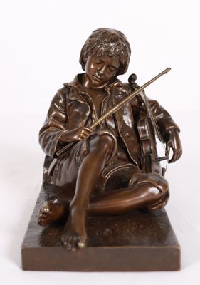 bronze statue of a boy sitting on a rock with a violin