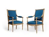 pair of blue upholstered armchairs with arms and legs