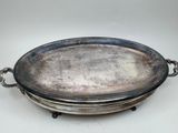 a silver plate with a chain around it on a white surface