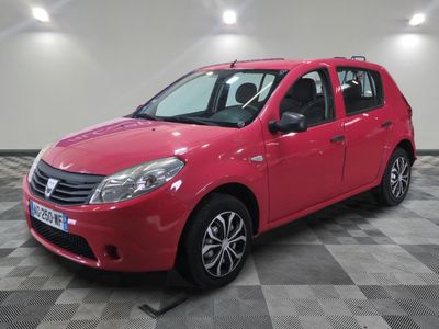La voiture rouge est garée sur un sol en carrelage à damier.