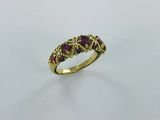 une bague en or jaune sertie de trois rubis au centre