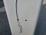 a white refrigerator sitting on the side of the road