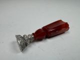 a close up of a silver and red object on a white surface