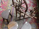 un rouet et des tabourets posés sur un tapis dans une pièce