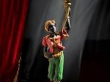 une statue représentant une femme tenant un chandelier devant un rideau rouge