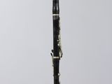 a black and white clarinet sitting on top of a clear stand