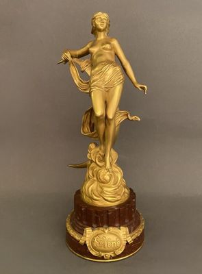 statue en or représentant une femme tenant un oiseau, posée sur un socle en marbre