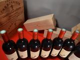 several bottles of red wine are lined up on a table