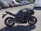 a black motorcycle parked in a parking lot with other cars