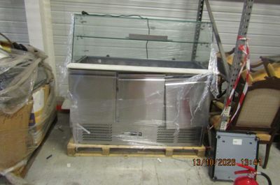 a refrigerator in the middle of a pallet in a warehouse