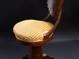 a wooden chair with a yellow upholstered seat on a black background