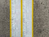 the back of a yellow and white sign on a concrete wall