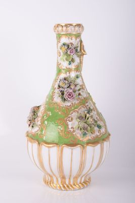 a green and white vase with flowers on it