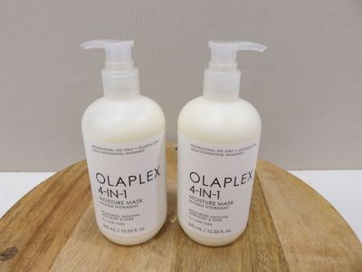two bottles of olaplex hand lotion on a wooden tray