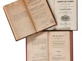 trois livres ouverts posés les uns sur les autres sur une table