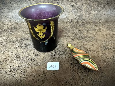 a purple vase and a small wooden object on the floor