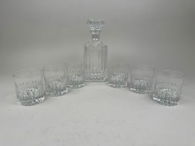 four glasses and a decanter sitting on a table