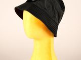 tête de mannequin jaune coiffée d'un chapeau noir