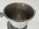 a metal cup with a handle on a stand