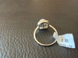 a close up of a ring on a leather surface with a price tag