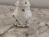 un petit vase blanc posé sur une table en marbre