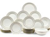 une photo montrant une pile d'assiettes blanches et dorées