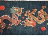 an oriental rug with a dragon design on a dark blue background