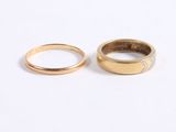 two gold wedding rings on a white background