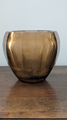 a brown glass bowl sitting on a wooden table