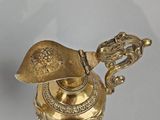 a small gold vase with a bird on top of it