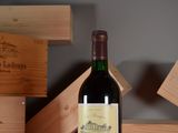 a bottle of wine sitting on a table next to a stack of wooden boxes