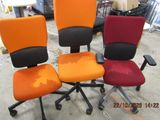 three office chairs are sitting in a row in a warehouse