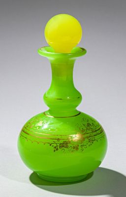 un vase vert surmonté d'une boule jaune