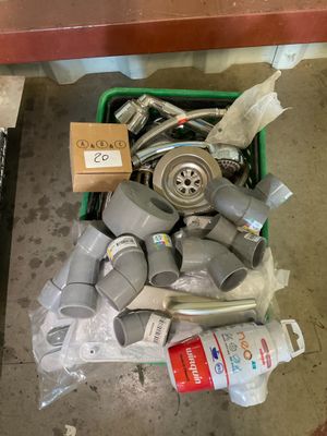 a green container filled with assorted items on the floor