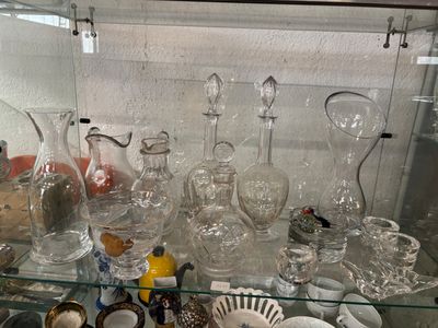 une vitrine remplie de vases et de plats en verre