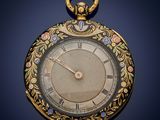 an antique gold pocket watch with a floral design on the face