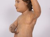 a small statue of a child with a hand on it ' s head