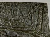 a bronze plaque of a bear and a bear cub in the woods