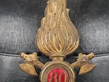 a black hat with a red and gold emblem on it