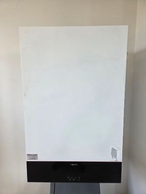 un tableau blanc posé sur un support noir dans une pièce