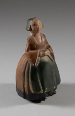 une figurine de femme assise sur une chaise