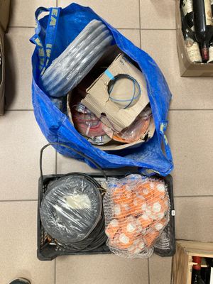 un sac bleu rempli d'objets posé par terre