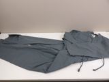 grey pants on a white table with a lamp on top of it